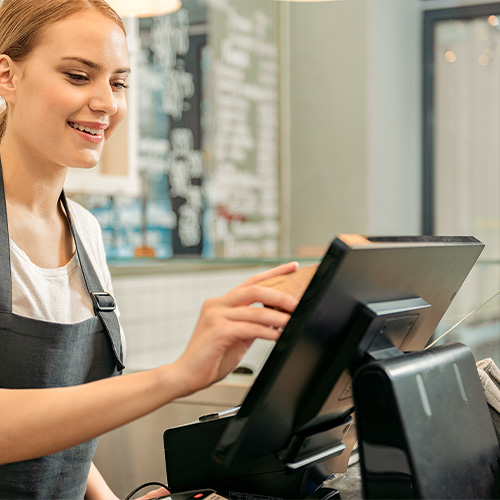 Woman using integrated EPOS system at counter